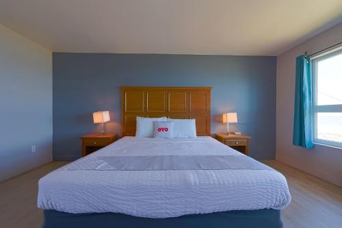 a bedroom with a large bed with two lamps at OYO Waves Hotel Newport OR - NYE Beach in Newport