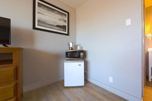 a kitchen with a microwave on top of a refrigerator at OYO Waves Hotel Newport OR - NYE Beach in Newport