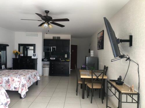 a bedroom with a bed and a desk and a ceiling fan at Condominio Yaqui 320 in San Carlos