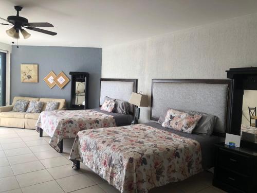 a hotel room with two beds and a couch at Condominio Yaqui 320 in San Carlos