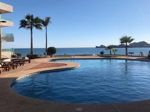 a swimming pool with a view of the ocean at Condominio Yaqui 320 in San Carlos