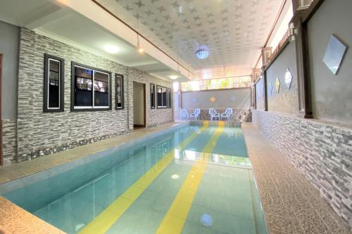 a large swimming pool in a building with a tile wall at Hotel O Bayu Sintok Motel in Changlun