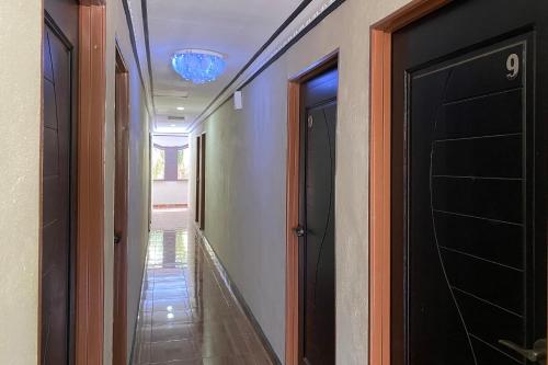 a hallway with a black door and a hallway with a light at Hotel O Bayu Sintok Motel in Changlun