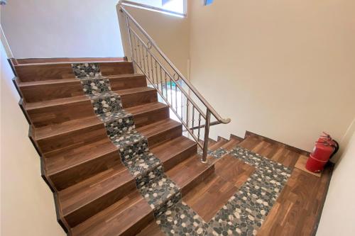 a stairwell with wooden floors and a stair runner at Hotel O Bayu Sintok Motel in Changlun