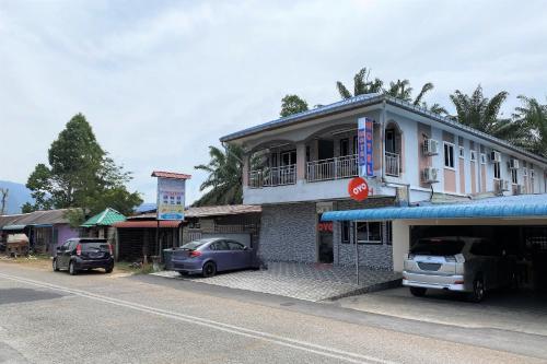 two cars parked in front of a building at Hotel O Bayu Sintok Motel in Changlun