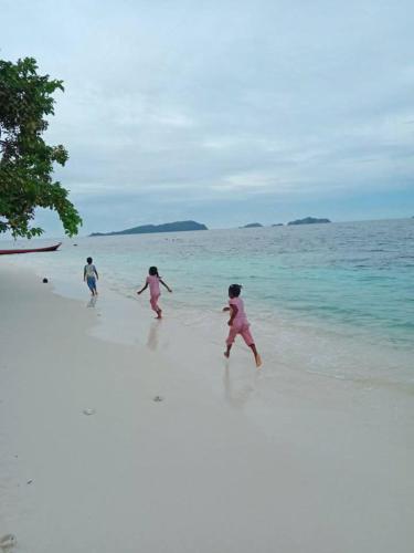 a group of children playing on the beach at Mares Homestay-Raja Ampat in Fam