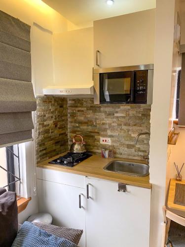 a small kitchen with a sink and a microwave at Artsy Chic Studio Apt Gidistays Lekki in Lekki
