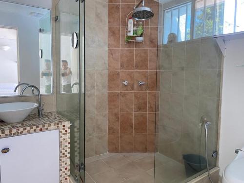 una ducha con puerta de cristal en un baño en HERMOSA VILLA FAMILIAR CONDOMINIO CAMPESTRE EL PEÑON Piscina Privada Campo de Golf, en Girardot