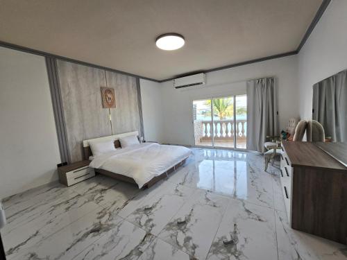 a bedroom with a bed and a marble floor at درة العروس فيلا هابي بيتش شاطى خاص in Durat  Alarous