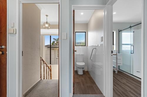 baño con aseo y pasillo en Sandbanks - Papamoa Beachfront Holiday Home, en Papamoa