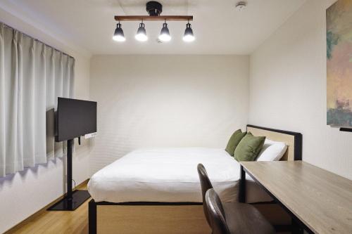 a bedroom with a bed and a table and a desk at Station Fujimigaoka in Kugayama