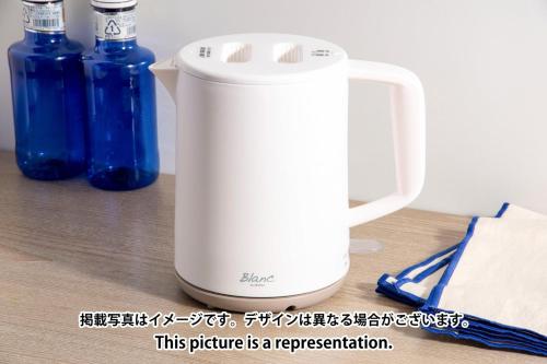 a white blender sitting on a table with two blue bottles at Station Fujimigaoka in Kugayama