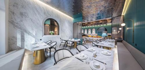 a restaurant with white tables and chairs in a room at Elegant International Hotel Shanghai - Bund Sichuan Road North Metro Station Branch in Shanghai