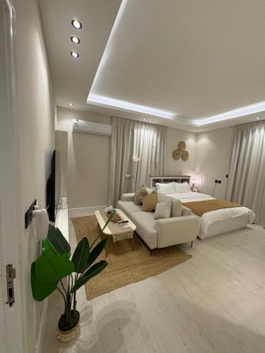 a white bedroom with a bed and a couch at Reefy studio 6 in Riyadh
