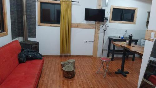 a living room with a red couch and a desk at Complejo Infinitus in Lanco