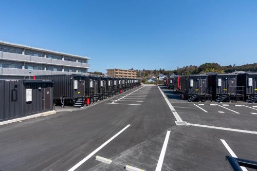 an empty parking lot with a bunch of containers at HOTEL R9 The Yard Otawara in Otawara