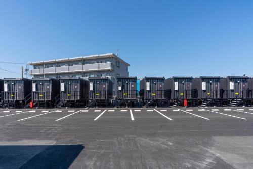 a parking lot with rows of containers in front of a building at HOTEL R9 The Yard Otawara in Otawara