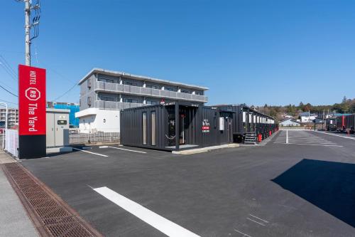 a parking lot with a row of black containers at HOTEL R9 The Yard Otawara in Otawara