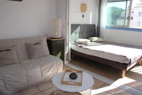 un salon avec un canapé et une table dans l'établissement Studio les pieds dans l'eau au Cap d'Agde, au Cap d'Agde