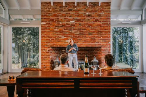 a woman standing in front of a brick wall at Littlebourne Guest House in Bathurst