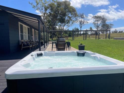 a hot tub on a deck with a yard at Serene bush cottage with an outdoor spa in Canyonleigh