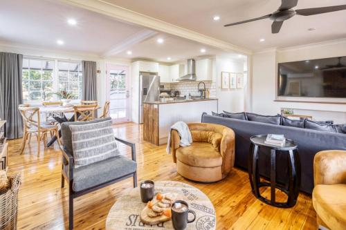 a living room with a blue couch and chairs at Serene bush cottage with an outdoor spa in Canyonleigh
