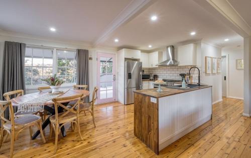 a kitchen and dining room with a table and a kitchen and a dining room at Serene bush cottage with an outdoor spa in Canyonleigh