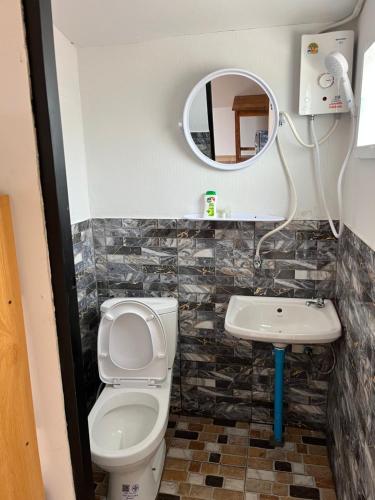 a bathroom with a toilet and a sink and a mirror at Thanya campsite Thailand in Ban Thai Thai