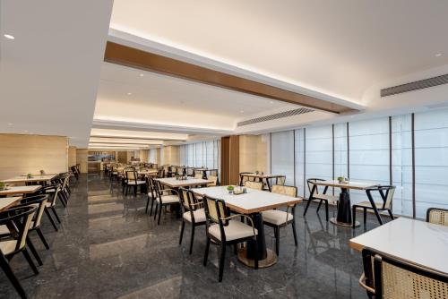 a dining room with tables and chairs and windows at Atour Hotel Guangzhou Railway Station University of Chinese Medicine - Complimentary Self-Service Laundry in Guangzhou