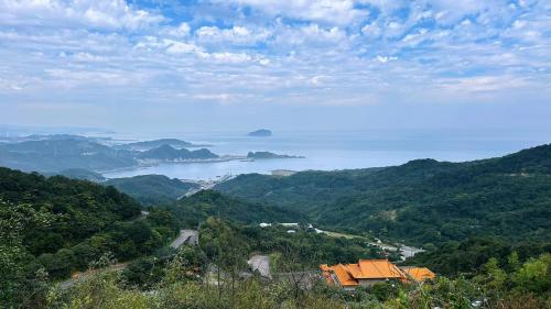 a view of the ocean from a hill with a house at 九份輕旅民宿 in Jiufen