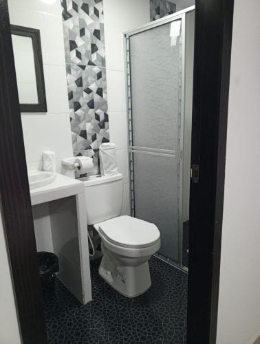 a bathroom with a toilet and a sink and a shower at Hotel El Redil in Ipiales