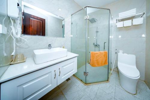 a bathroom with a sink and a glass shower at Golden Sea Hotel in Ha Long