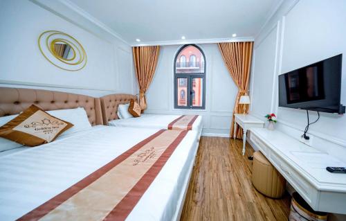 a bedroom with two beds and a flat screen tv at Golden Sea Hotel in Ha Long