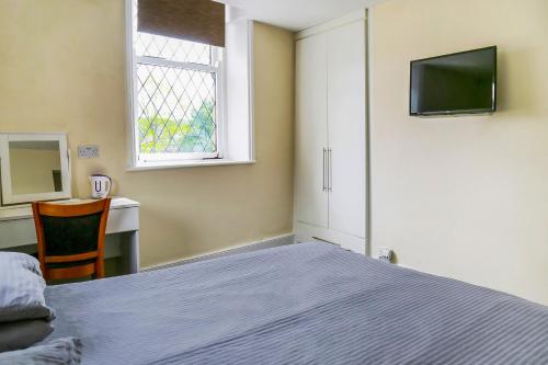 a bedroom with a bed and a desk and a television at OYO Castle Hotel, Accrington in Accrington