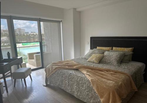 a bedroom with a bed and a desk and a window at Marina Corazón Sea View - Condo Puerto Cancún in Cancún