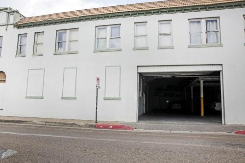 a large white building with a garage at OYO Historic Cameron Hotel Brownsville I-69E in Brownsville