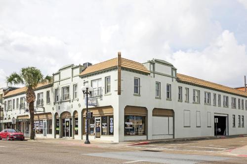 a white building on the corner of a street at OYO Historic Cameron Hotel Brownsville I-69E in Brownsville