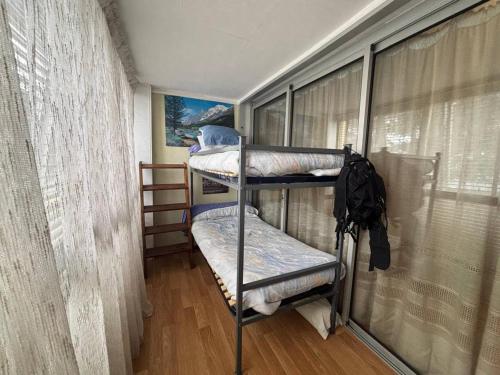 deux lits superposés dans une chambre avec fenêtre dans l'établissement Appartement 2 pièces cabine avec parking et garage au centre - FR-1-593-131, aux Angles