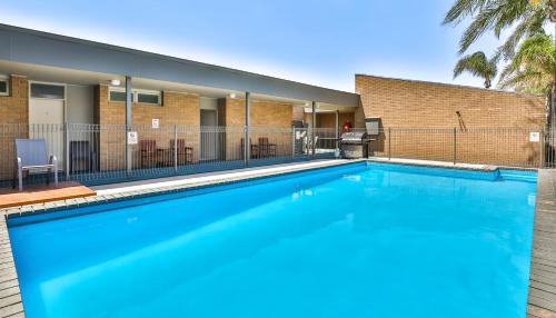 a large blue swimming pool in front of a building at Cottonwood Motor Inn in Mildura