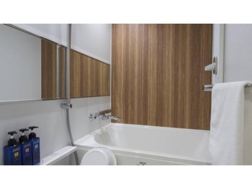 La salle de bains est pourvue d'une baignoire, de toilettes et d'un miroir. dans l'établissement Tmark City Hotel Sapporo Odori - Vacation STAY 85621v, à Sapporo