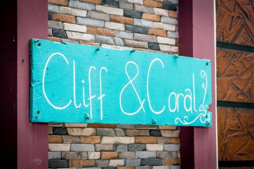 a blue sign on the side of a brick building at Cliff & Coral in Varkala