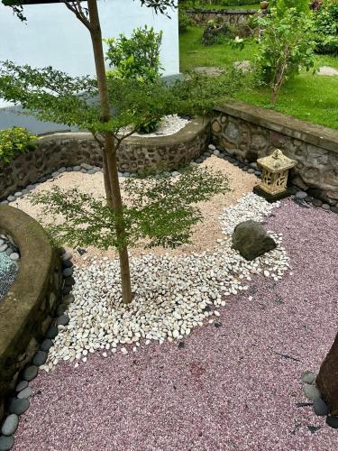 a garden with a small tree and rocks at Beehive Cottages in Amed
