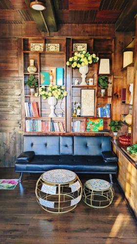 a blue couch and two tables in a room at Villa Hoa Như - View Nhà Lồng in Trai Mat
