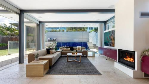 a living room with a couch and a fireplace at Beachcomber in Kiama Downs