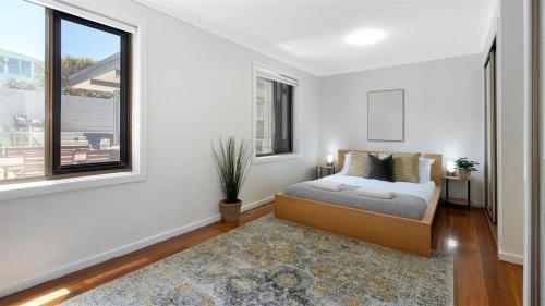 a bedroom with a bed and a window at Beachcomber in Kiama Downs