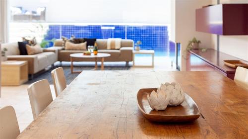 a living room with a wooden table and a living room with a couch at Beachcomber in Kiama Downs