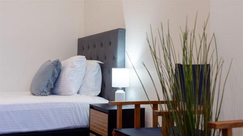a bedroom with a bed and a table with a lamp at Beachcomber in Kiama Downs