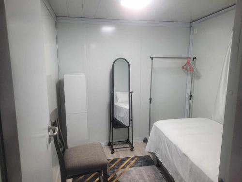 a room with a bed and a mirror and a chair at Avondale Place in Nuku‘alofa