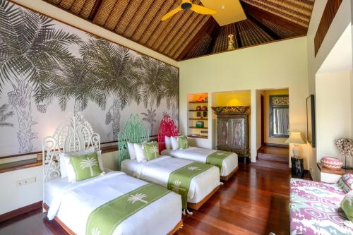 a bedroom with three beds with green and white at Villa Palem in Tabanan