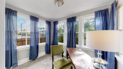 a dining room with blue curtains and a table and a lamp at Chic Denver Family Retreat Free Parking & Prime Location in Denver